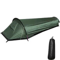Army green single-hoop bivvy tent pitched with guy lines on a white background, shown beside its black stuff sack
