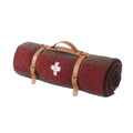 Wool camping blanket rolled with two leather carry straps and a handle, brown with a red stripe and cream cross