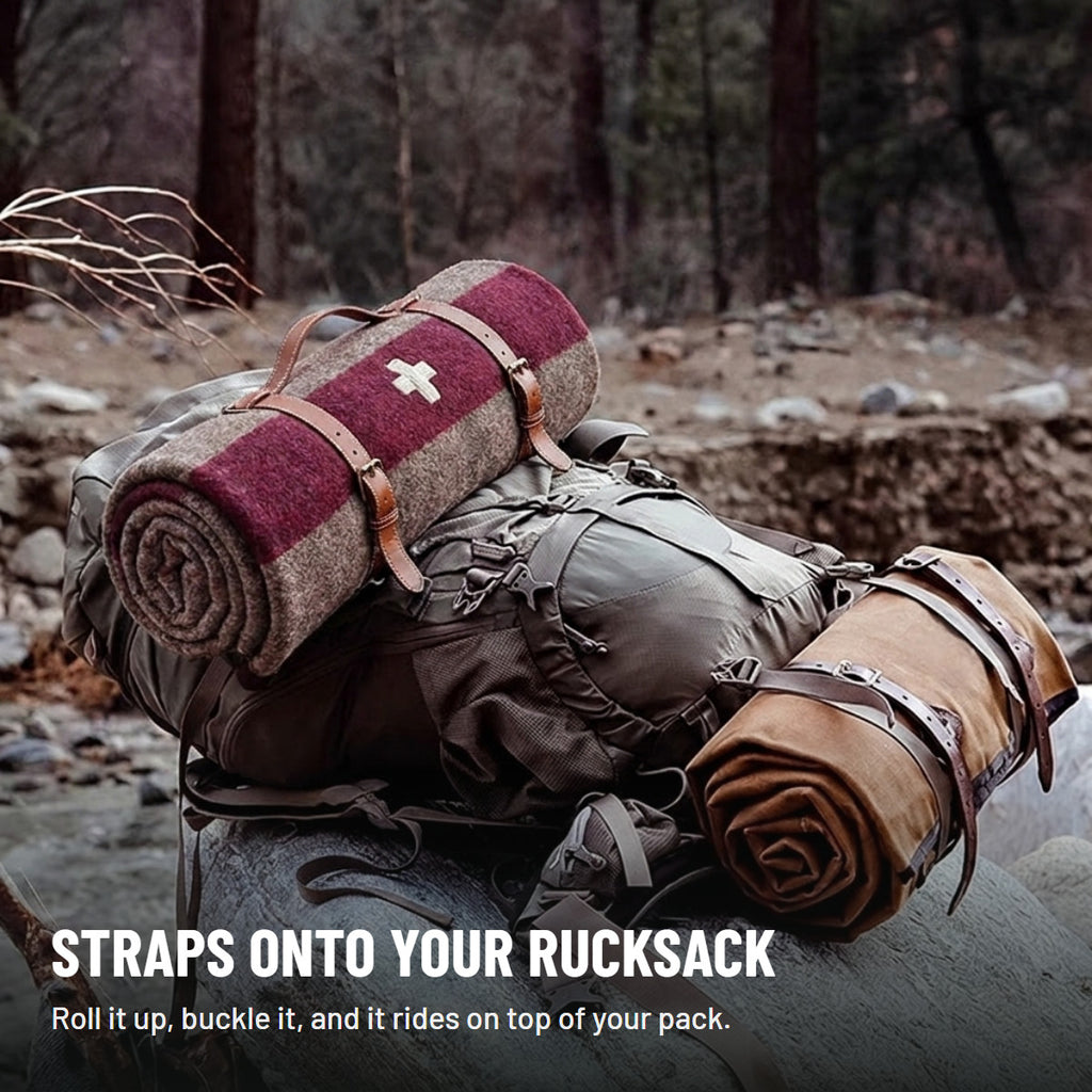 Rolled blanket strapped to the top of a rucksack resting on a rock