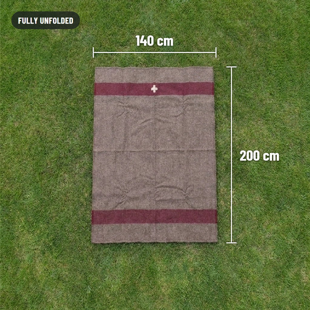 Blanket fully unfolded on grass, 140 cm by 200 cm, with a red stripe near each end